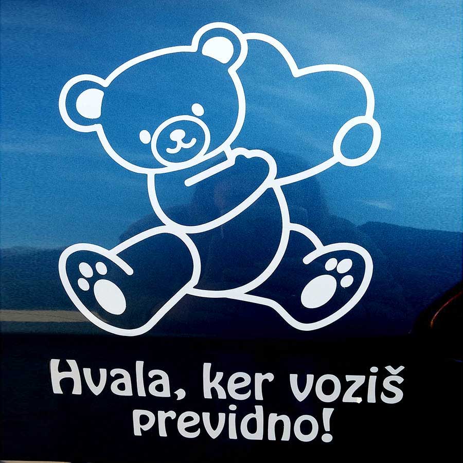 Bela nalepka medvedka z besedilom po želji na avtomobilskem steklu.