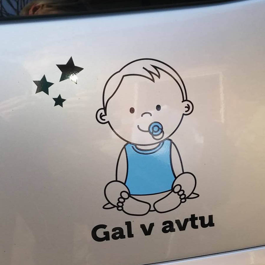Modra nalepka sedečega dojenčka z dudo, zvezdicami in besedilom po želji na karoseriji avtomobila.